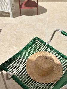 a straw hat sitting on top of a green rack at Lux Maris by Jdvacanze in Campomarino