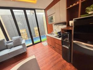 a kitchen with a couch and a large window at Villa Srikandi Caldera D5 in Tlekung