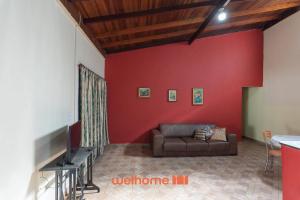 a living room with a couch and a red wall at Sitio em Sumare com piscina e lazer completo in Sumaré +40 photos