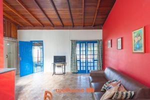 a living room with a couch and a red wall at Sitio em Sumare com piscina e lazer completo in Sumaré