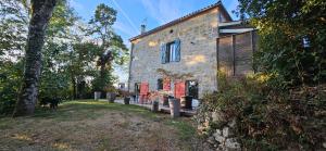 an old stone house with a dog in front of it at Locagites82 in Moissac