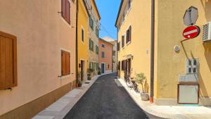 an alley with yellow buildings and a bike on a street at Apartment Lux in Novigrad Istria