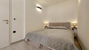 a bedroom with a bed and two lights on the wall at Apartment Lux in Novigrad Istria