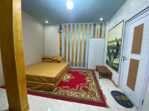 ein kleines Schlafzimmer mit einem Bett und einem Teppich in der Unterkunft Kabin Sahara in Pulau Tidung-kecil