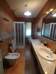 a bathroom with two sinks and a toilet at Casa La Bolandrina Lago Barasona in La Puebla de Castro +33 photos