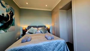 a bedroom with a bed with blue slippers on it at Luxusowy Apartament MonteNegro in Nowęcin