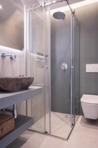 a bathroom with a glass shower with a sink and a toilet at El Mar Seaview Penthouse 2 BDR, 7 min from beach in Lagonissi +15 photos