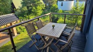 a wooden table and two chairs on a deck at Luxusowy Apartament MonteNegro in Nowęcin