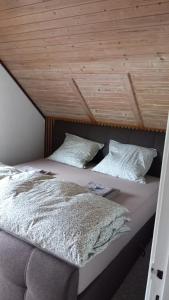 two beds in a room with a wooden ceiling at Holiday Nest 2 in Sønderborg