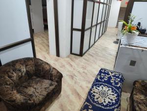 a living room with a couch and a chair at D'Yogi Rooms & Dormitory in Varanasi