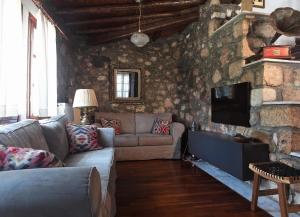 a living room with a couch and a stone wall at Olivia Country House in Panayía