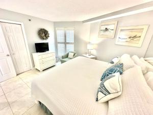 Un dormitorio con una cama blanca y un televisor. en 4336 Beachside Two, en Destin 37 fotos más