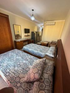 a hotel room with two beds and a television at شاليه بقرية اكوافيو in El Alamein +8 photos