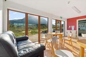 a living room with a couch and a table and chairs at Errigal Hostel in Gweedore