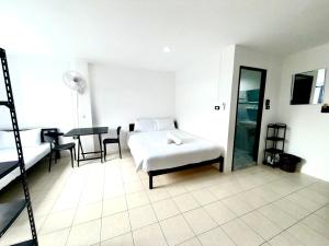 een slaapkamer met een bed, een tafel en stoelen bij Patong Canal Villa R202 in Patong Beach