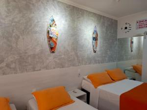 twee bedden in een kamer met surfplanken aan de muur bij FLAT AMARÍLIS - RIVIERA DE SÃO LOURENçO in Riviera de São Lourenço