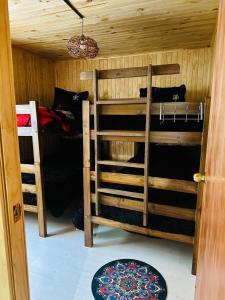 a room with two bunk beds and a door at Cabañas Alturas Chillan Benjamin in Recinto