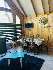 a dining room with a table and chairs and a tv at Cabañas Alturas Chillan Benjamin in Recinto