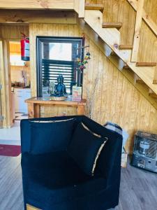 a blue couch in a living room with a staircase at Cabañas Alturas Chillan Benjamin in Recinto