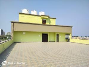 un grand bâtiment jaune avec un toit dans l'établissement Twilight Residency, à Bhubaneswar