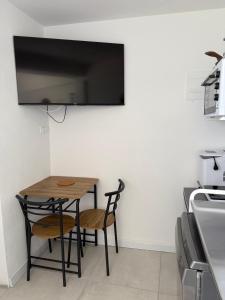 a kitchen with a table with chairs and a tv on the wall at Studio Bire in Lumbarda
