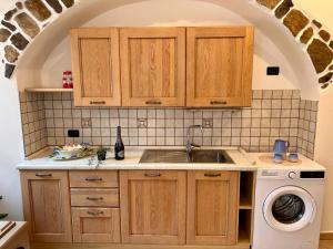 a kitchen with a sink and a washing machine at Appartamento al volt in Tenno