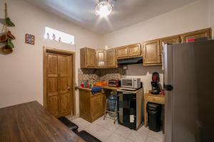 a kitchen with wooden cabinets and a stainless steel refrigerator at Casa El Ombligo de la Luna in Guanajuato