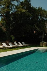 a swimming pool with chaise lounge chairs and a swimming pool at Bellevigne Bourgogne in Chambolle-Musigny
