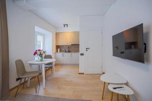 a kitchen and dining room with a table and chairs at Green Apartment with free parking in Kaunas +16 photos
