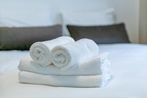 a pile of towels sitting on top of a bed at Green Apartment with free parking in Kaunas