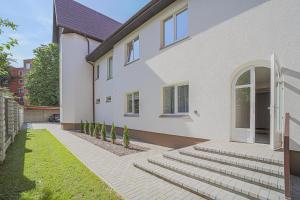 a white house with stairs in front of it at Green Apartment with free parking in Kaunas