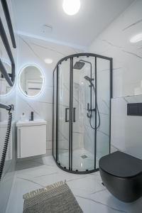 a bathroom with a shower and a black toilet at Green Apartment with free parking in Kaunas