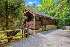 a log cabin with a wooden porch and a fence at Mountain Dream By Avada Properties in Sevierville