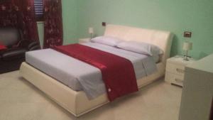 a bedroom with a white bed with a red blanket at Chia View Pool, AC, Garden Relaxation in Chia