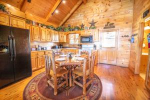 een keuken met een tafel en een zwarte koelkast bij Mountain Getaway 2 By Avada Properties in Sevierville