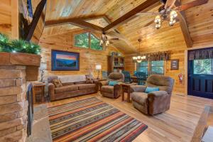 een woonkamer in een blokhut met een open haard bij Misty Mountain Cabin By Avada Properties in Pigeon Forge