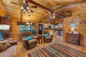 een woonkamer van een blokhut met stoelen en een keuken bij Misty Mountain Cabin By Avada Properties in Pigeon Forge