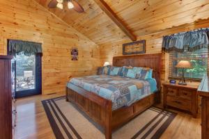 een slaapkamer met een bed in een blokhut bij Misty Mountain Cabin By Avada Properties in Pigeon Forge