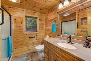 een badkamer in een blokhut met een wastafel en een toilet bij Misty Mountain Cabin By Avada Properties in Pigeon Forge +33 foto's