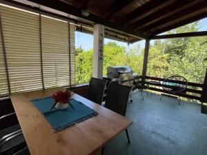 a table and chairs on a porch with a grill at LEA in Bakarac