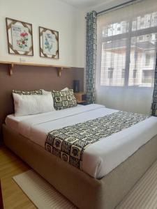 a bedroom with a large bed with a window at Best homes apartments near JKIA in Nairobi +12 photos