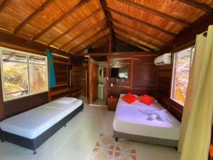 a bedroom with two beds in a small room at Belcys House Sapzurro in Sapzurro