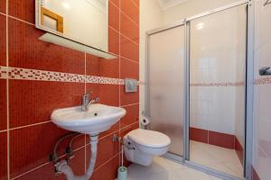 a bathroom with a toilet and a sink and a shower at A spacious, comfortable and cozy apartment close to the center of Fethiye in Fethiye +10 photos