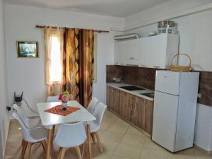a kitchen with a table and a white refrigerator at Villa Agim,Hena in Vlorë