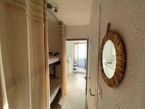 uno specchio a muro accanto al bagno di Aux Jardins du Vidourle - 3 min à pied de la Plage, Parking, Clim & Wi-Fi a La Grande-Motte