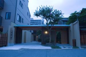 un bâtiment avec un arbre au milieu d'une rue dans l'établissement Yadoya Nishijinso, à Kyoto