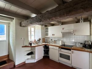 una cucina con mobili bianchi e una grande finestra di Ty an Holen Maison de Pêcheur à 300 m de la mer a Piriac-sur-Mer