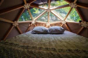 a bed in a room with a large window at L'Orée des 4 chemins in Fontenoy