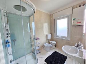 a bathroom with a shower and a sink and a toilet at Appartamento Il Faggio in Borgo
