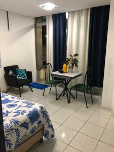 a living room with a table and chairs in a room at Apartment Pé na Areia - Guarapari in Guarapari